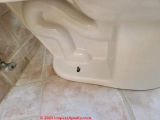 New toilet mounting bolts show up through holes in the toilet base (C) Daniel Friedman at InspectApedia.com