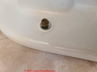 Toilet mounting bolt plastic snap ring, washer, and cap nut in place (C) Daniel Friedman at InspectApedia.com