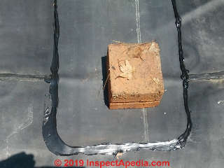 Weights on rubber roof repair strip during curing (C) Daniel Friedman at InspectApedia.com