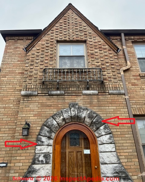 Black stains on brick and limestone building exterior are not from roof wash-down nor from roofing felt under slate shingles. Most likely it's an algae stain (C) InspectApedia.com KS