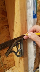 Marking the cut height lines on the wall stud to be extended on to the exterior wall so that we have proper height above the floor to use the round hole saw for Cinderella toilet installation  - (C) Daniel Friedman at InspectApedia.com