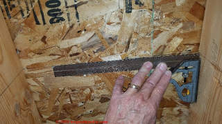 Using a try square to extend our cut line height from a mark on the wall stud onto the exterior wall sheathing  - (C) Daniel Friedman at InspectApedia.com