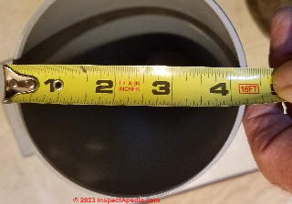 Measurement of the actual outer diameter of the 4-inch plastic pipe used to vent the Cinderella incinerating toilet - actually 4 5/8 inches  - (C) Daniel Friedman at InspectApedia.com