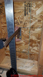 Using a framing square and try square to measure precisely from finished floor surface in to mark the interior side of exterior wall sheathing  - (C) Daniel Friedman at InspectApedia.com