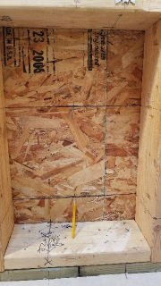 Final reveiw of wall marks showing where to set the pilot bit for the round hole saw during a Cinderella incinerating toilet installation - (C) Daniel Friedman at InspectApedia.com