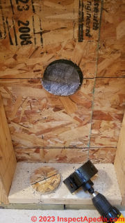 Inside cut of round hole in wall for Cinderella toilet is complete - now move outside  - (C) Daniel Friedman at InspectApedia.com