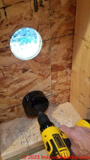 Starting to cut lower air inlet vent pipe hole in wall for Cinderella toilet installation  - (C) Daniel Friedman at InspectApedia.com