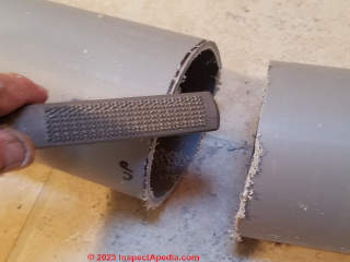 Using a rasp to file smooth the cut edges of the Cinderella vent or air inlet pipes  - (C) Daniel Friedman at InspectApedia.com