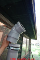 Installing the lower 45 degree elbow to extend our incinerating toilet vent out past the roof edge  - (C) Daniel Friedman at InspectApedia.com