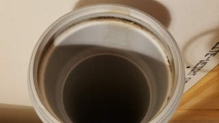Cleaning the dirty gasket and hub to get a reliable pipe seal when assembling the vent for a Cinderella incinerating toilet  - (C) Daniel Friedman at InspectApedia.com