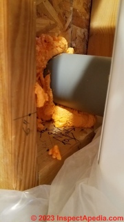 Use fire block foam to insulate and glue in place the air inlet and exhaust outlet for the Cinderella incinerating toilet  - (C) Daniel Friedman at InspectApedia.com