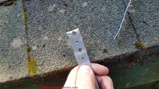 Bend over end of steel strapping when making add-on incinerating chimney support brace  - (C) Daniel Friedman at InspectApedia.com