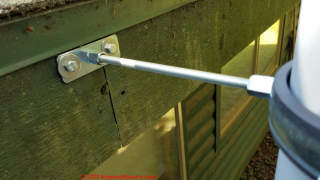 Threaded rod and clamp chimney brace affixed to roof edge fascia board  - (C) Daniel Friedman at InspectApedia.com