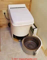 Accessing the waste pan on a Cinderella Comfort incinerating toilet (C) InspectApedia.com 
