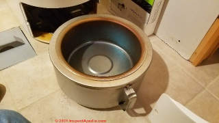 Insert the Cinderella ash pan into the toilet base (C) InspectApedia.com