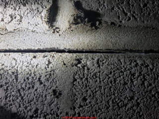 Wavy mortar in block wall joint appears to be due to loading during construction (before mortar hardened) (C) InspectApedia.com Cory