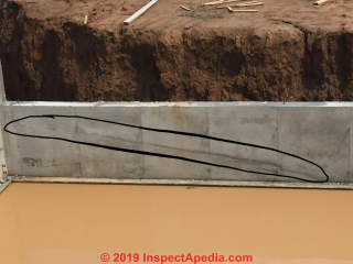 Cold pour joint lines in a new concrete foundation wall during construction (C) InspectApedia.com Chad