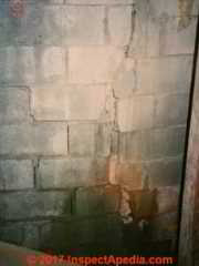 Severe vertical break in a concrete block wall © Daniel Friedman at InspectApedia.com