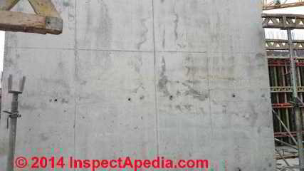 Dark areas suggesting cold pour joints in a concrete wall (C) InspectAPedia CI