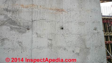 Dark areas suggesting cold pour joints in a concrete wall (C) InspectAPedia CI