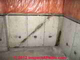 Photograph of contraditory diagonal "cracks" in a poured concrete foundation wall (C) InspectAPedia & C.C. 