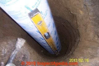 Checking the level of the cardboard form tube for a concrete pier (C) InspectApedia.com Galow Construction