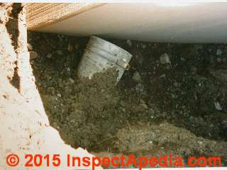 Construction debris tossed into backfill at a pre-cast foundation wall © Daniel Friedman at InspectApedia.com