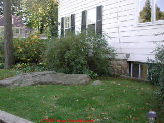 Water entry in part due to sloping rock near the home foundation (C) Daniel Friedman at InspectApedia.com