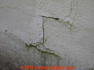Concret block wall diagonal step cracking shows thorugh foundation coating © Daniel Friedman at InspectApedia.com