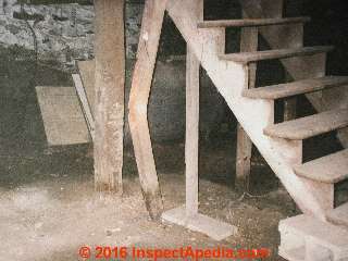 Extreme bend in a wooden post at a basement stair © Daniel Friedman at InspectApedia.com