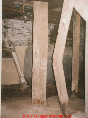 Broken collapsing wood post in a basement (C) Daniel Friedman at InspectApedia.com