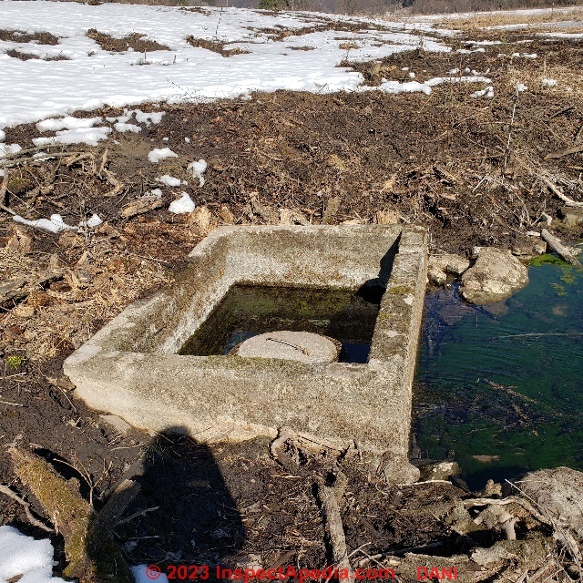 Concrete spring box with unexplained center masonry cistern and cover (C) Inspectapedia.com Dani